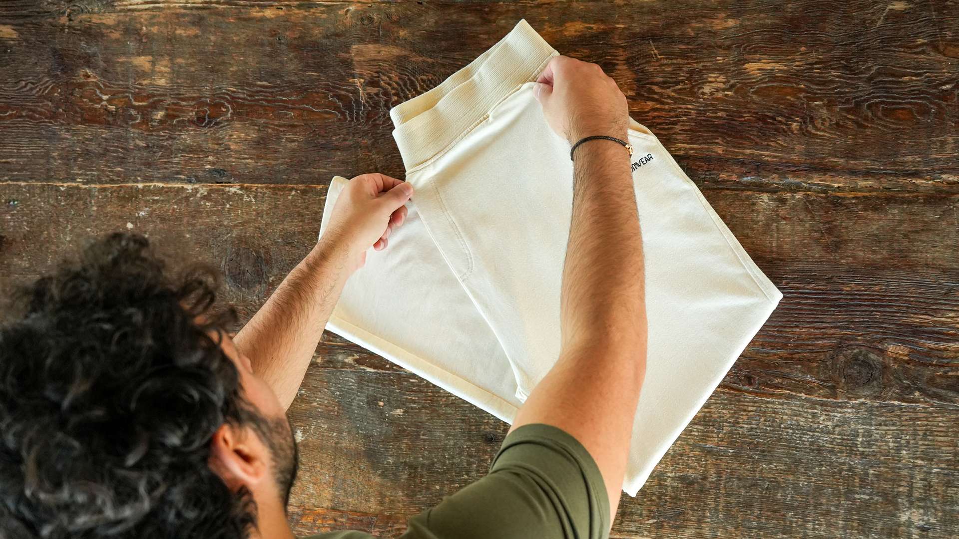 A man folding a premium loungewear pants